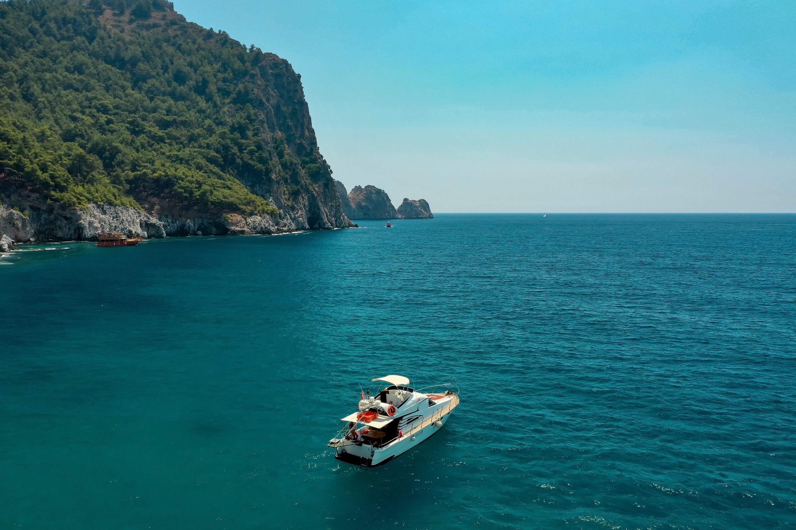 Sailboat in the sea in the evening sunlight over beautiful big mountains background, luxury summer adventure, active vacation in Mediterranean sea, Turkey